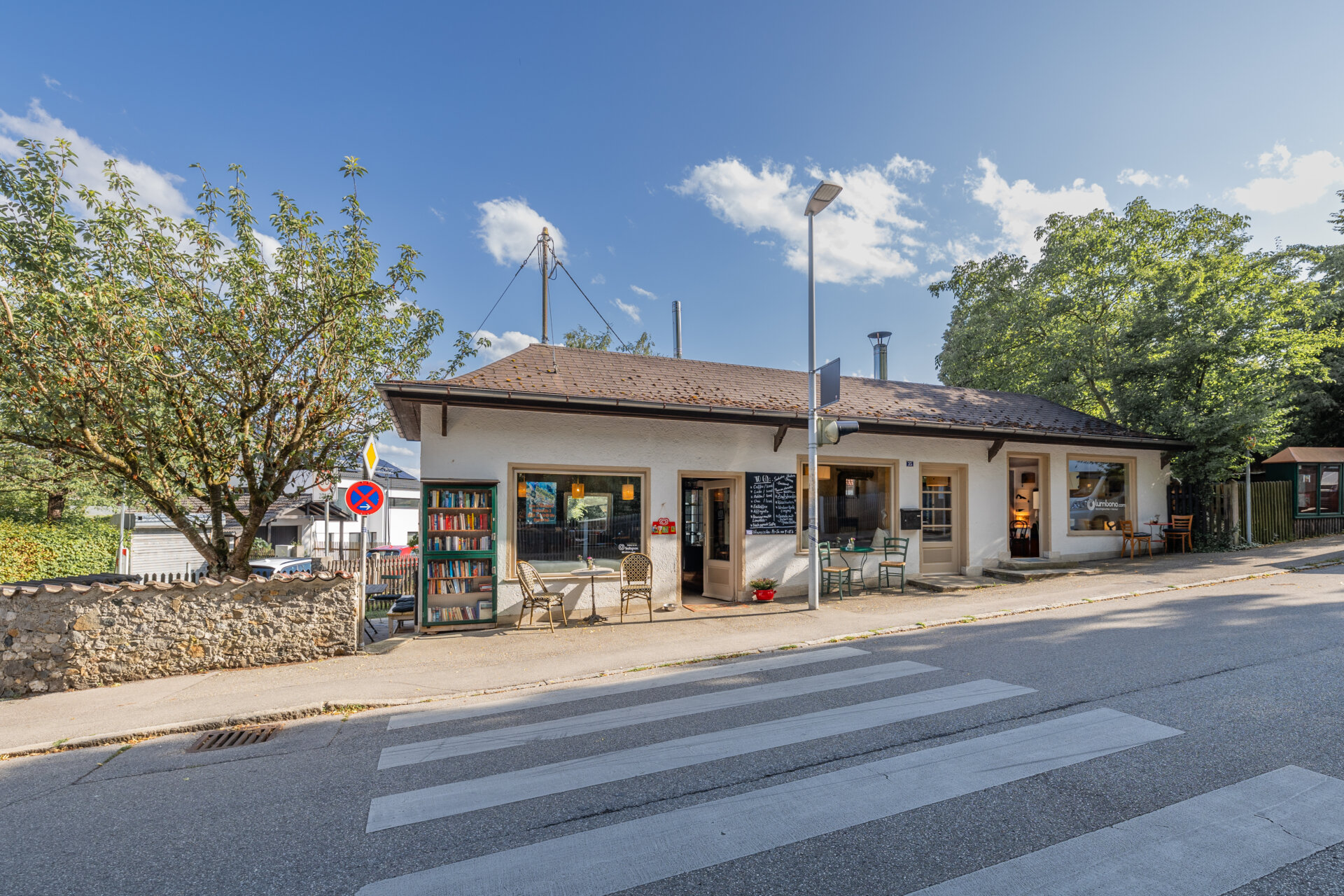 Die Café Bar lumbono in der Bahnstraße 35 in Stockdorf mit Tischen vor dem Haus